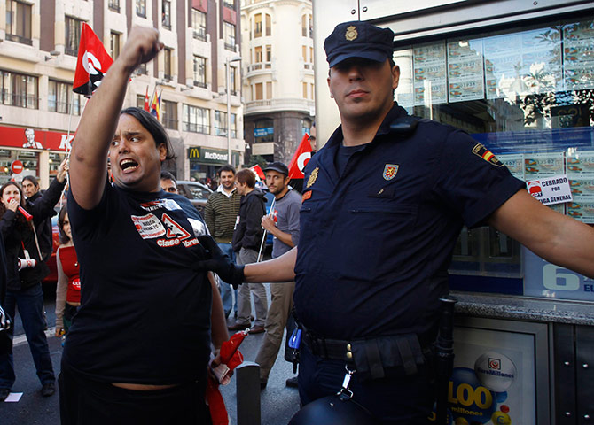 European strikes: A policeman stops a picketer as they demand for the closure of some shops