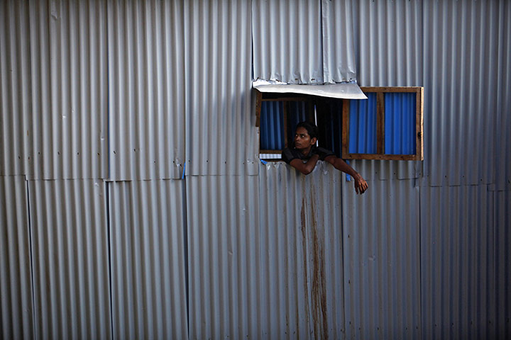 24hours Wed: A man looks out of a window from a shanty in Dharavi