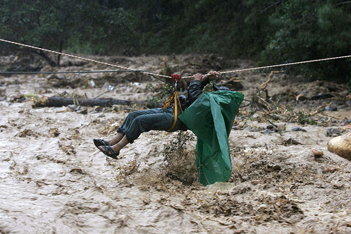 24hours Wed: A villager crosses a river on the outskirts of Santa Maria Tlahuitoltepec