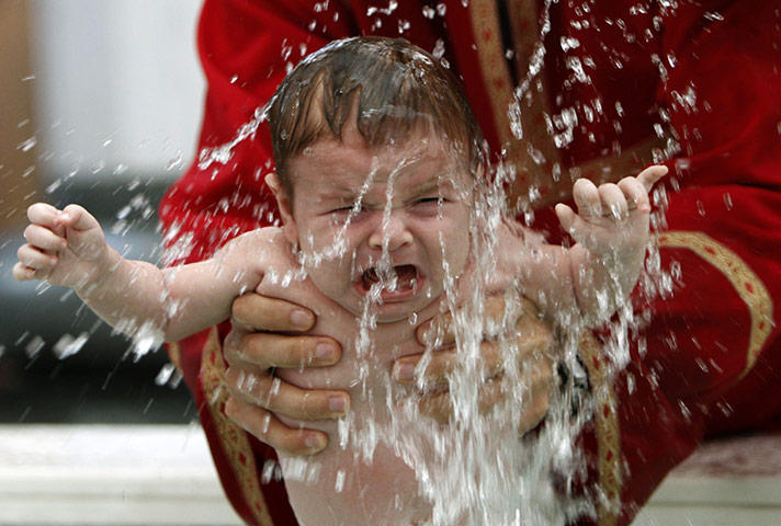 24hours Wed: A baby is baptized during a mass baptism ceremony in Tbilisi