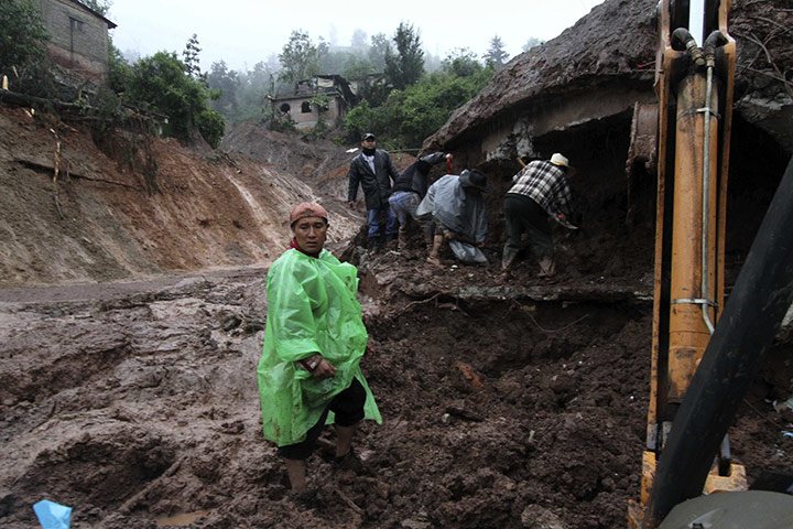 Mexico mudslides: Men look inside a home that was buried after a landslide in Tlahuitoltepec