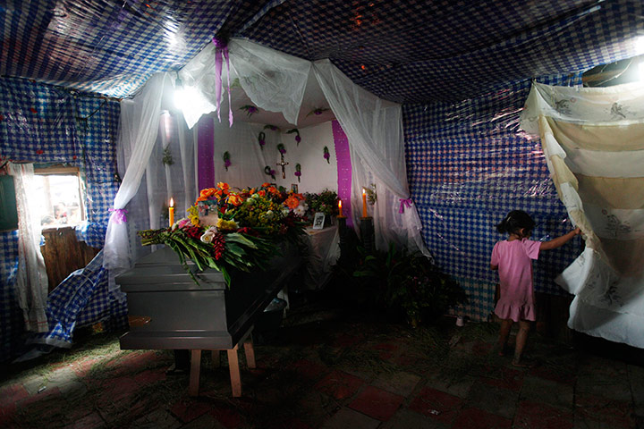 Mexico drug war: A girl walks next to the coffin of murdered immigrant Miguel Carcamo