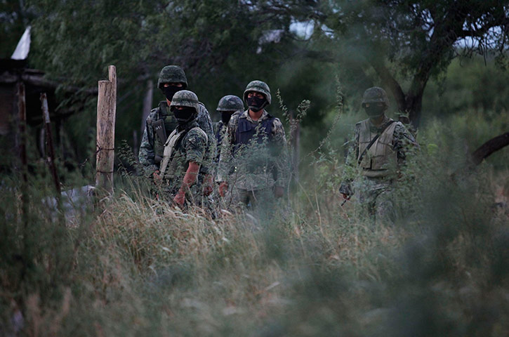 Mexico drug war: Soldiers stand guard after a gunfight with drug gang members