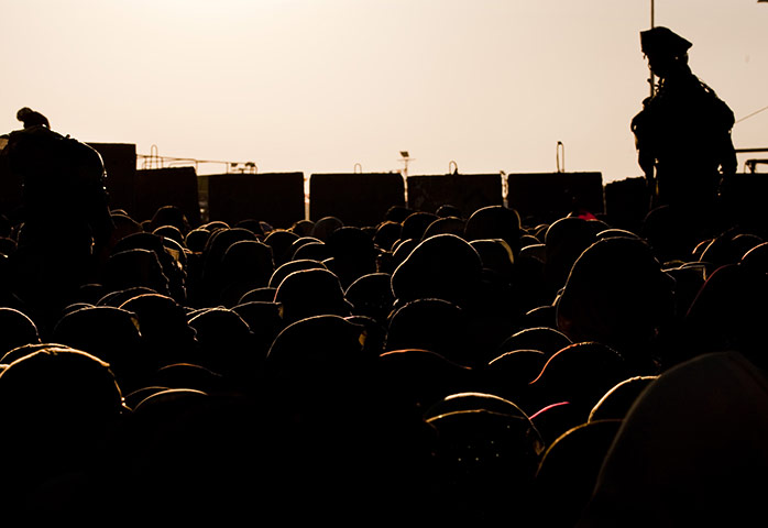 24 Hours: Palestinian women wait to cross the Kalandia checkpoint to pray