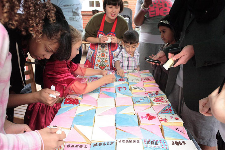 Liverpool Road: A young woman helps children ice cakes outside