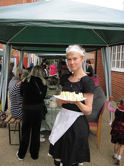 Liverpool Road: A young woman in waitress dress holds a plate of sandwiches