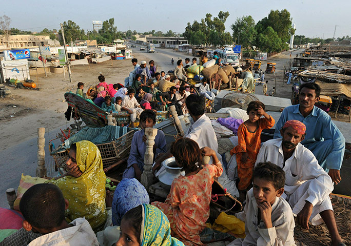 24 Hours: Pakistan flood survivors sit on a trucks