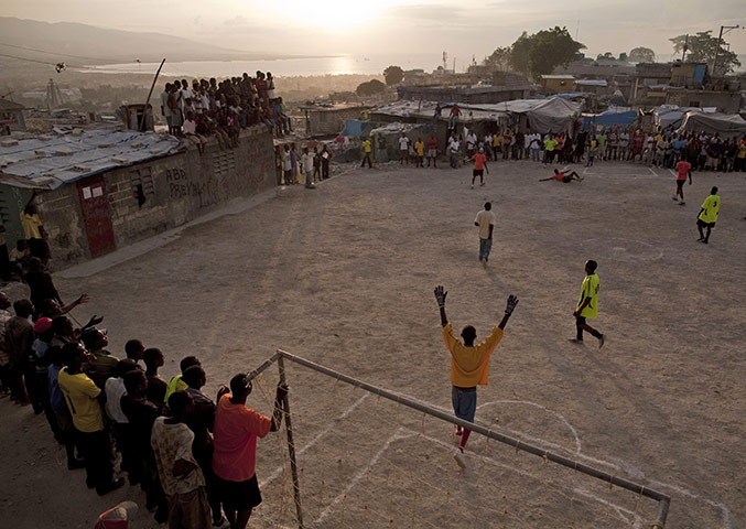 24 Hours: People play soccer in Port-au-Prince, Haiti as the sun sets