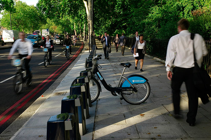 Tube stirke: Cyclists and pedestrians walk past lone hire cycle amongst the empty racks