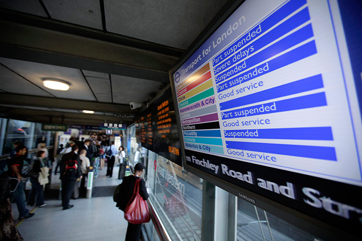 Tube stirke: Commuters walk past an information board giving details about strike