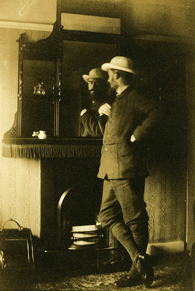 George Bernard Shaw: Self portrait, Shaw stands leaning on a mantelpiece 