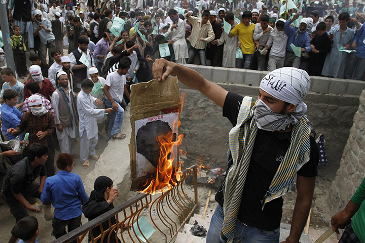 Quran Protest : An Afghani protester burns a portrait of pastor Terry Jones