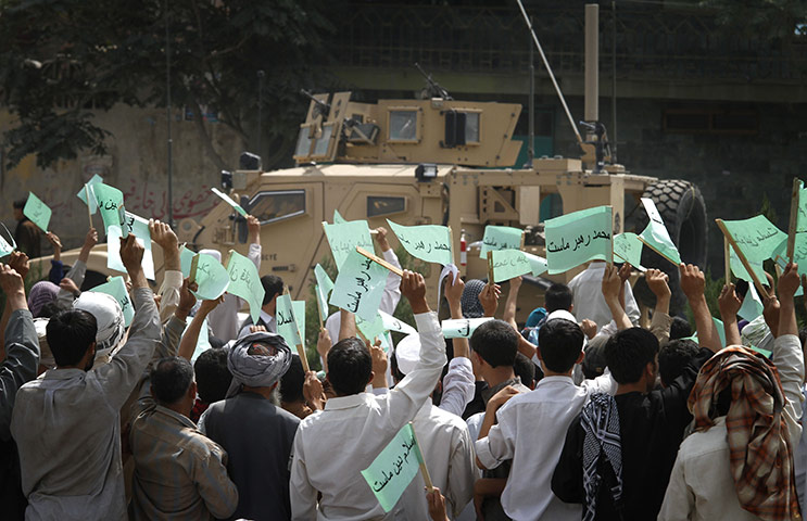 Quran Protest : Afghans wave banners during a demonstration against the United States