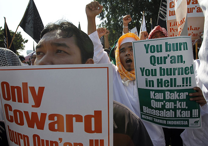 Quran Protest : Members of the Islamic group hold placards by the U.S. embassy in Jakarta