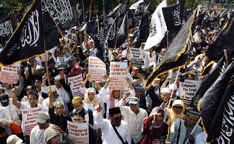 Quran Protest : Members of the Islamic group hold placards by the U.S. embassy in Jakarta