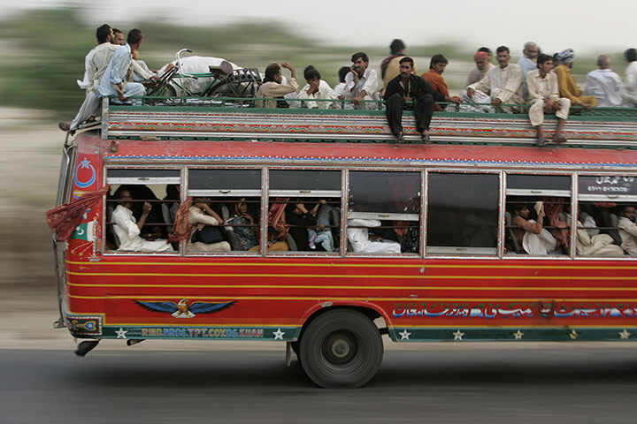 Pakistan Flooding Update: Pakistanis displaced by floods sit on top of a bus Pakistan flooding