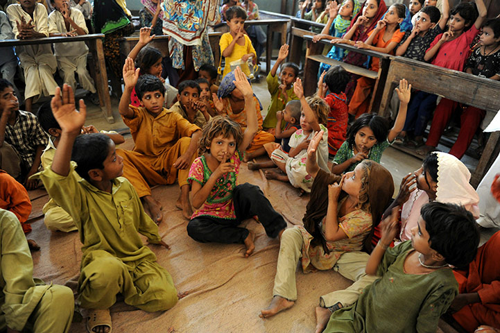 Pakistan Flooding Update: Internally displaced Pakistani children wait for food packages