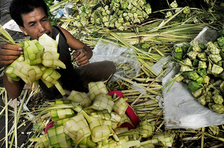 Eid Al-Fitr Festival: A stall vendor weaves a 