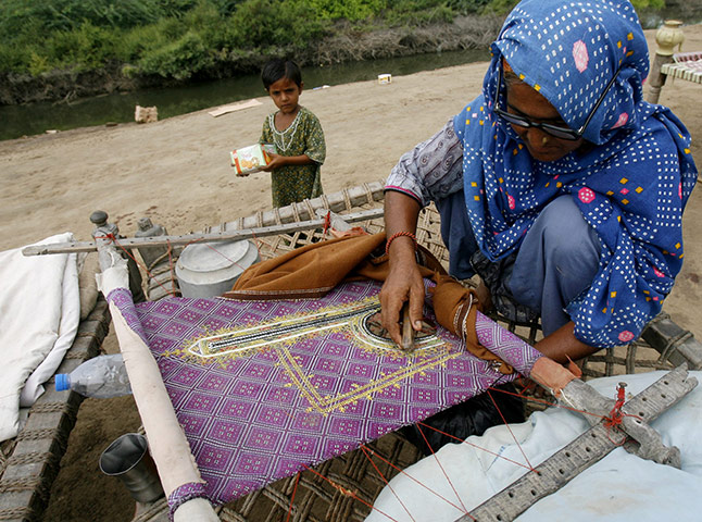 Eid Al-Fitr Festival: Ummi, 45, a victim of the floods, sews a qameez for her daughter