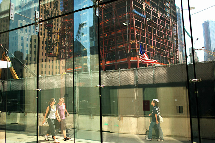 24 hours in pics: People walk by One World Trade Centre under construction at Ground Zero
