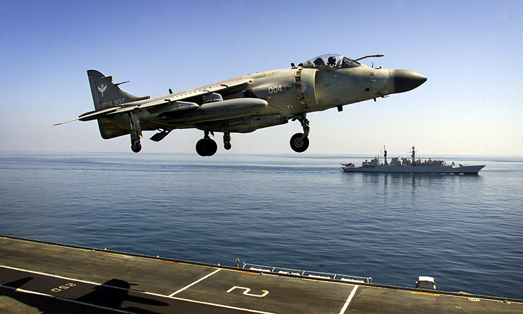 Week in Business: A Royal Navy Sea Harrier passes over the deck of HMS Illustrious