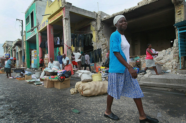 Haiti then and now: January 2011: A woman walks past the previously looted building