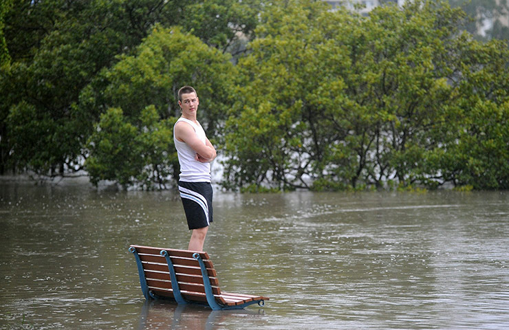 Queensland floods: A local on looks the the Brisbane River as it rises rapidly 