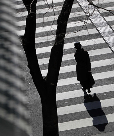 24 hours in pictures: A woman crosses a street in Tokyo