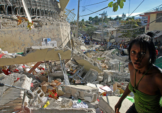 Haiti one year on: January 13: Haitians pass destroyed buildings in Port-au-Prince