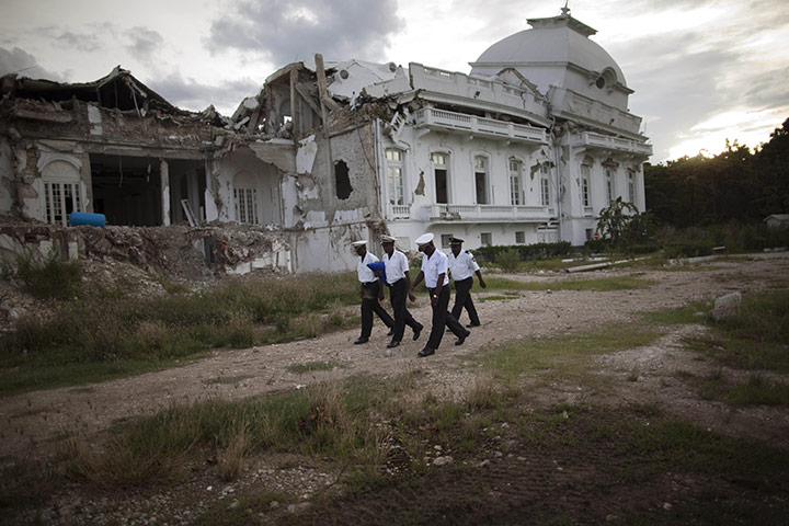 Haiti one year on: October 1: Police carry a Haitian flag after taking it down