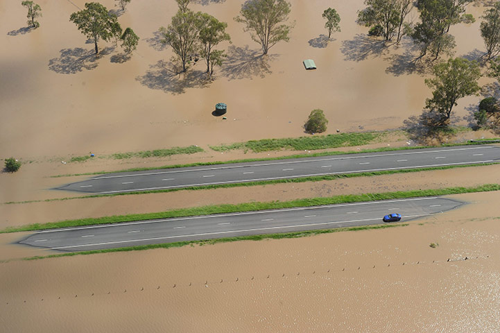Brisbane floods: A car is stranded in flood waters on the Warrego Highway west of Brisbane