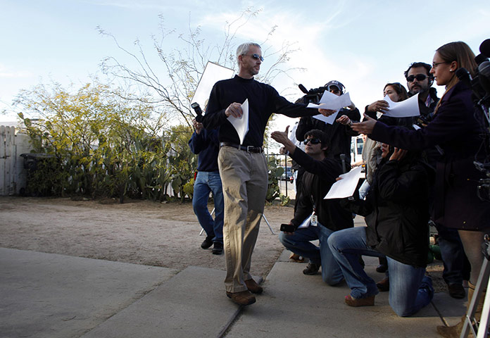 Tuscon shooting: A man hands out copies of a statement from the family of Jared Lee Loughner
