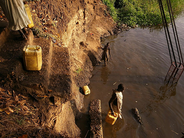 Southern Sudanisn: Women fill-up water canisters in the Nile River, Sudan