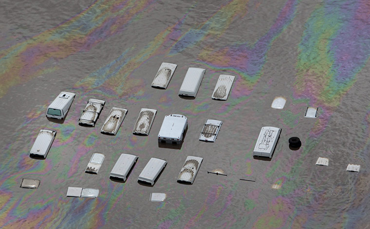 Aerials Brisbane floods: Oil swirls around vehicles submerged by flood waters in an industrial area 