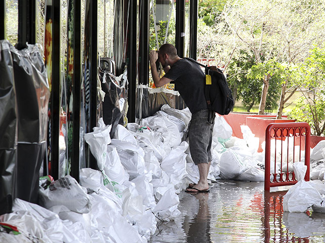 Aerials Brisbane floods: A local resident peeks into a flooded shop in New Farm