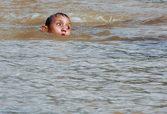 Brazil floods: A boy submerged in flood water in Sao Paulo
