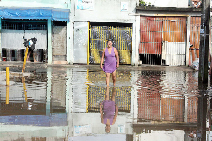 Brazil floods: Woman wades through flood in Sao Paulo