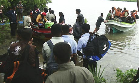 Sri Lankan rescuers evacuate residents of the eastern district of Batticaloa by boat as floods rise