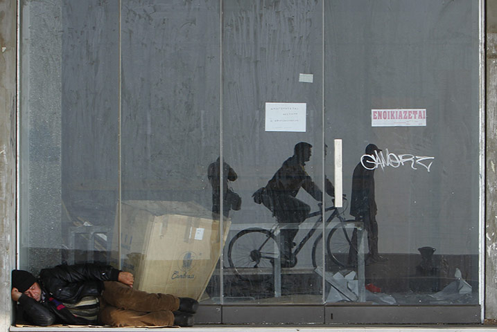 Week in business: A man sleeps outside a vacant shop in Thessaloniki