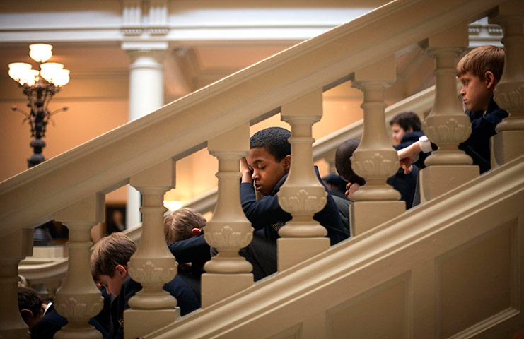 24 hours in pictures: A member of the Atlanta Boy Choir, observes a moment of prayer