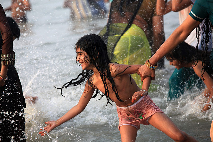 24 hours in pictures: An Indian girl enjoys the holy dip in the Bay of Bengal