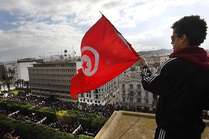 protests in tunisia: A protester waves the Tunisian flag