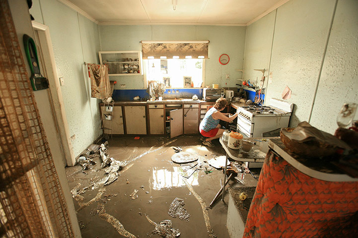 Brisbane Cleanup: A volunteer helps clean the kitchen of a property damaged by floodwaters