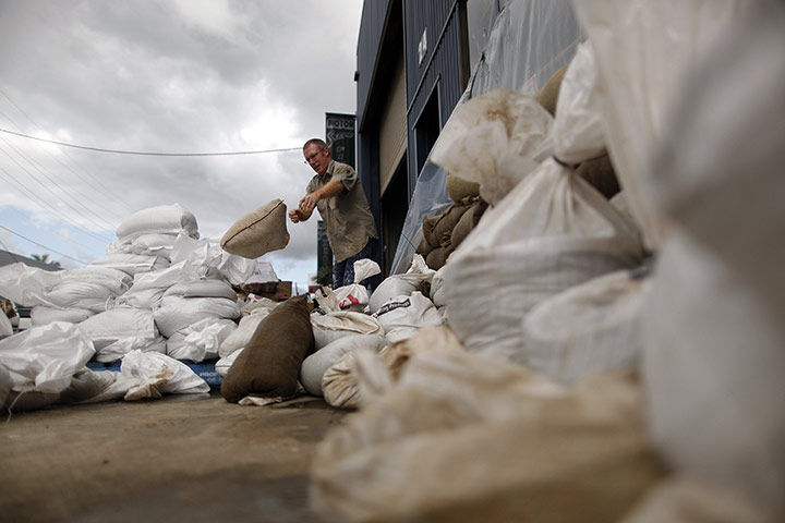 Brisbane Cleanup: A man removes sandbags from the entrance to a flood-damaged warehouse