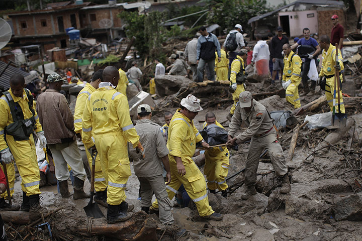 brazil mudslide aftermath: Rescue workers remove a body after a landslide in Teresopolis