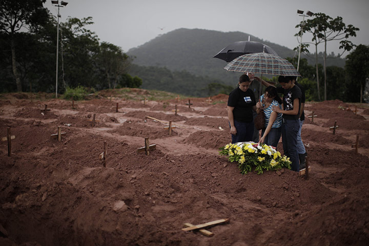 24 Hours: eople mourn after the burial of a landslide victim in Brazil