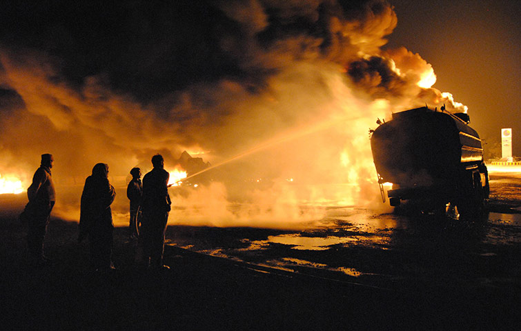 24 Hours: A fireman tries to extinguish burning fuel tankers in Pakistan