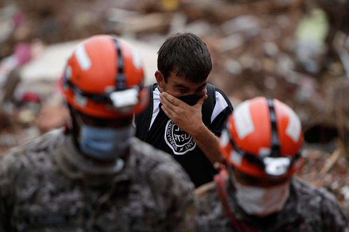 Brazil aftermath: Rescue workers try to recover the body of a landslide victim