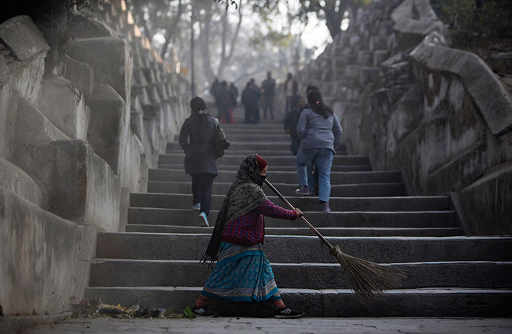 24 hours in pics:  A Nepalese worker sweeps the steps leading to a temple