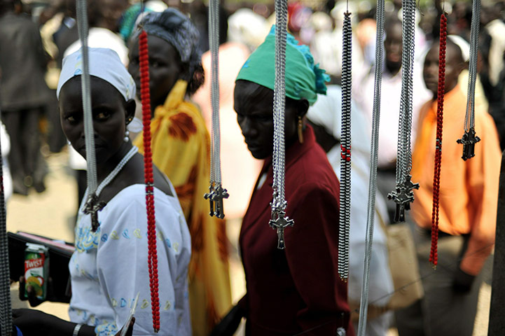 Sudan election: Christian women look at crucifixes for sale outside a local church